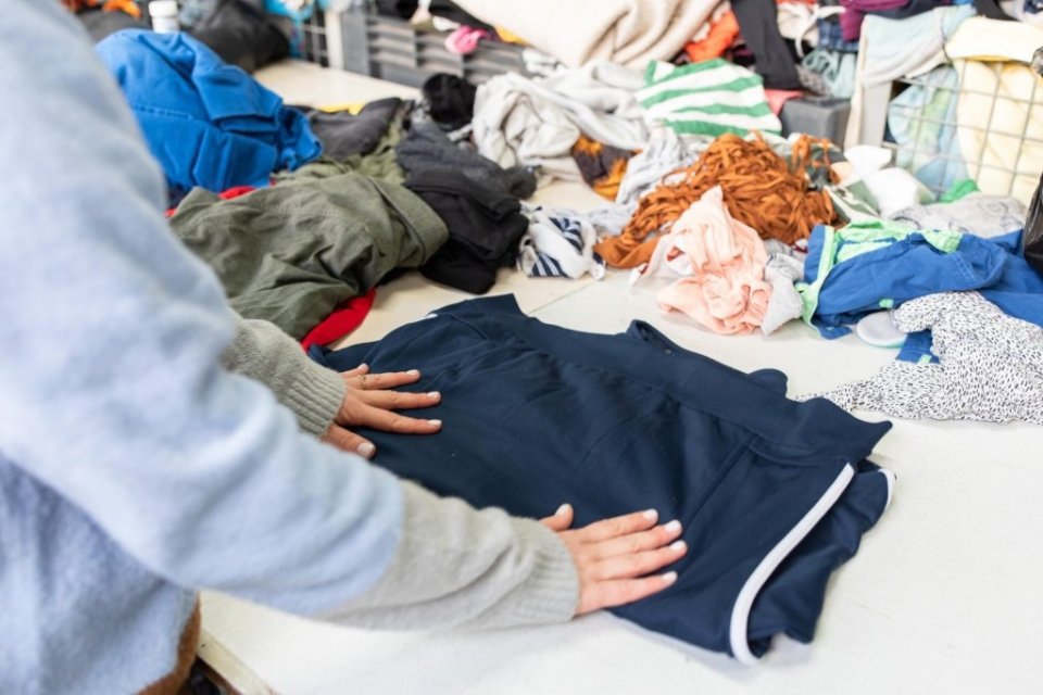 Kleding wordt gesorteerd in het sorteercentrum snuffelmug van Spaarne Werkt