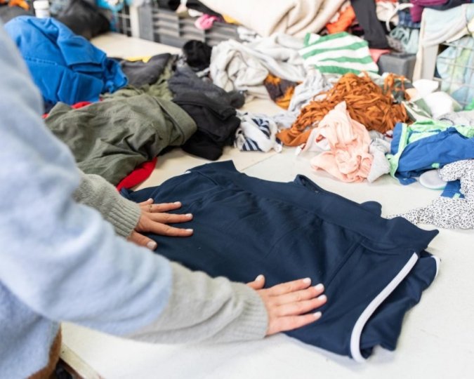 Kleding wordt gesorteerd in het sorteercentrum snuffelmug van Spaarne Werkt